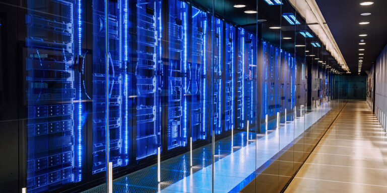 A modern data center with rows of illuminated blue server racks lining a sleek corridor, representing the advanced technology powering AI development.