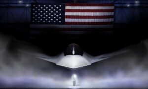 A dark hangar with a large American flag hanging overhead, illuminating a stealthy, angular aircraft shrouded in mist, with a spotlight highlighting its nose and a small figure standing below.