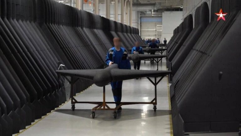 A row of large, wing-shaped Garan drones being assembled in a Russian factory, highlighting the scale of production.
