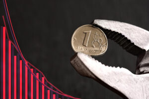 A Russian soldier in a green uniform stands in a muddy, war-ravaged field with destroyed vehicles and a smoky sky in the background.