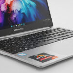 Aluminum Aim Max Plus laptop open on desk showing display and keyboard.